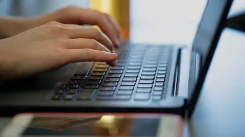 Hands typing on laptop
