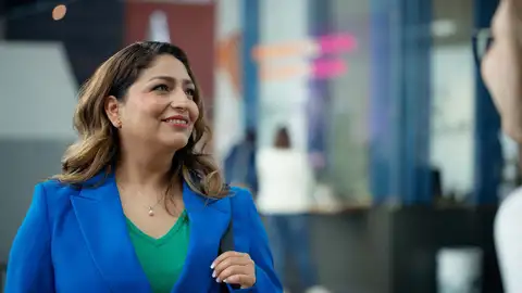 Person looking to her right with Arcada's info desk in the background.