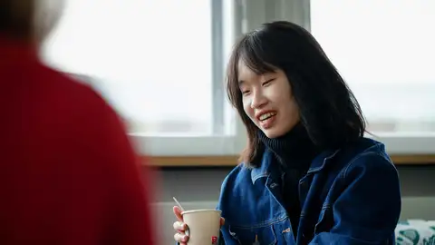 Person holding take away mug.