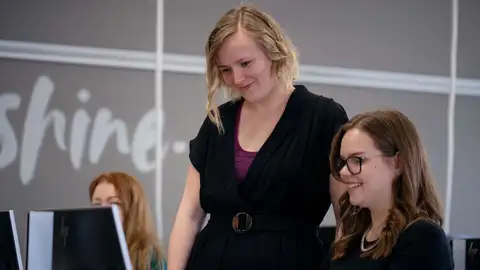 Three people by computers.