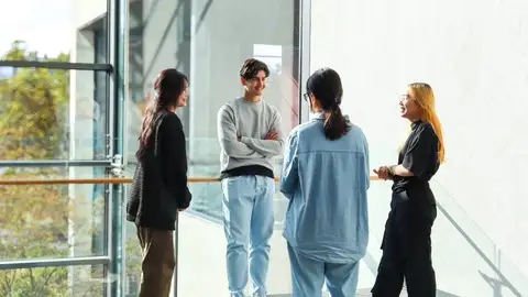 Four people standing and discussinng.