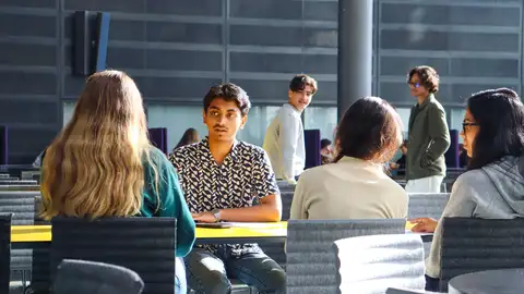 Students discussing around table.